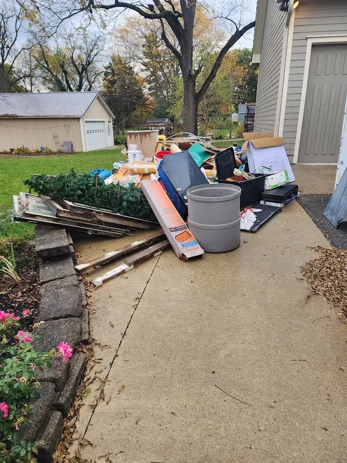 Dumpster being loaded with debris for 10 Yard Dumpster Rental in St. James